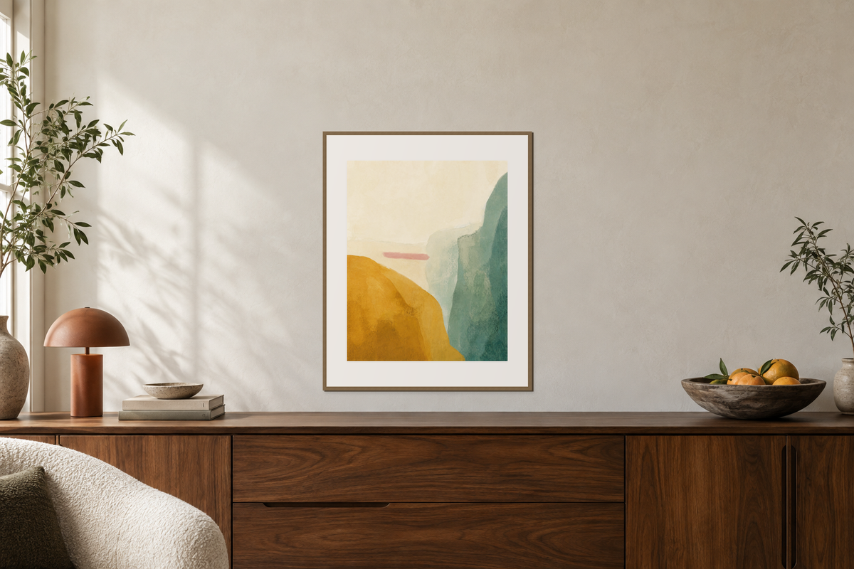 A colorful abstract print above a walnut sideboard with a lamp and low fruit bowl.
