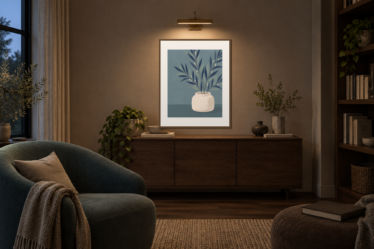A framed botanical print below a brass picture light in a softly lit reading room.
