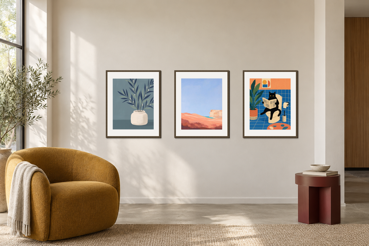 A botanical print, a colorful abstract and a cat print grouped above a mustard chair.