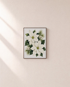 Winter Bloom white poinsettia print: unframed print is shown framed for styling on a plain wall; frame not included
