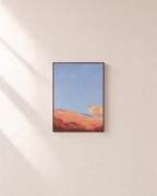 Coral Dune Below Blue Sky blue and coral abstract wall art print: unframed print is shown framed for styling on a plain wall; frame not included
