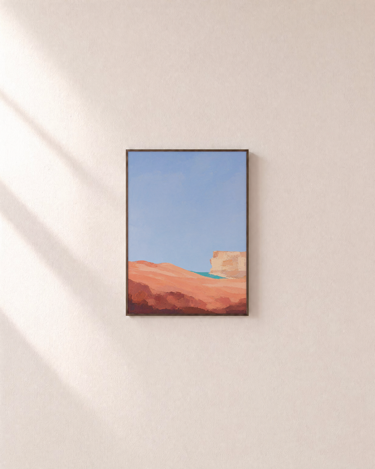 Coral Dune Below Blue Sky blue and coral abstract wall art print: unframed print is shown framed for styling on a plain wall; frame not included