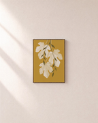 Sheer Fig Leaves Mustard unframed print is shown framed for styling in a plain wall; frame not included