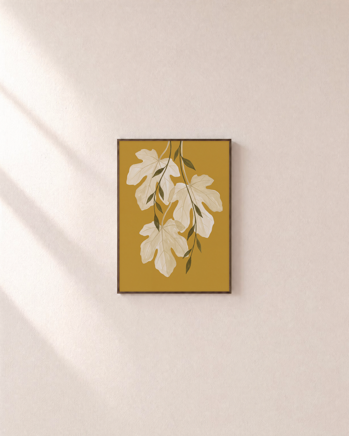 Sheer Fig Leaves Mustard unframed print is shown framed for styling in a plain wall; frame not included