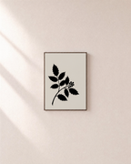 Single Plant Silhouette black leaf wall art: unframed print is shown framed for styling on a plain wall; frame not included