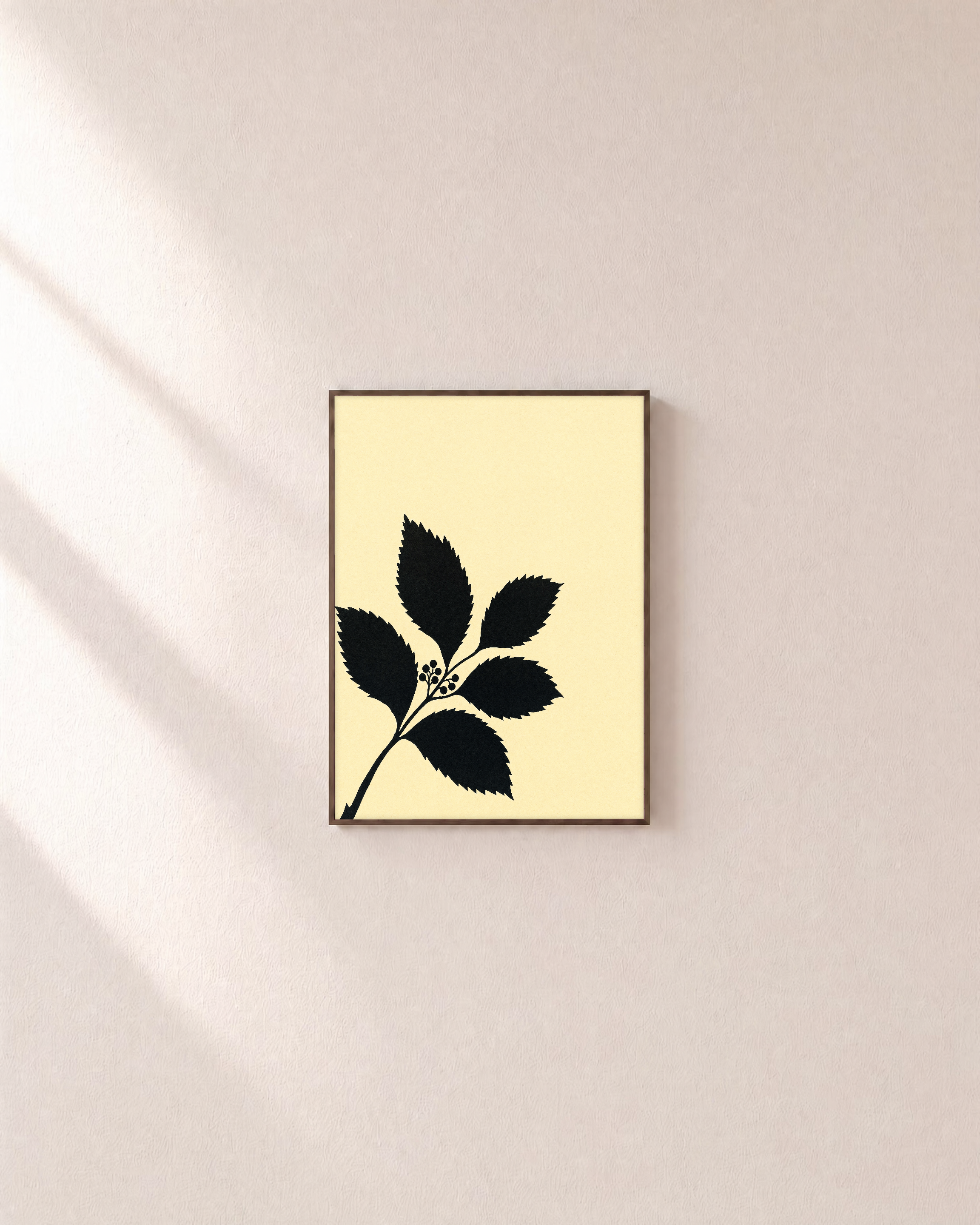 Black Leaf Sprig unframed print is shown framed for styling in a plain wall; frame not included