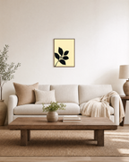 Black Leaf Sprig unframed print is shown framed for styling in a living room; frame not included