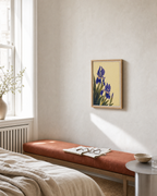 Iris Cluster at Lower Left purple iris flower study wall art print: unframed print is shown framed for styling in a bedroom sitting area; frame not included