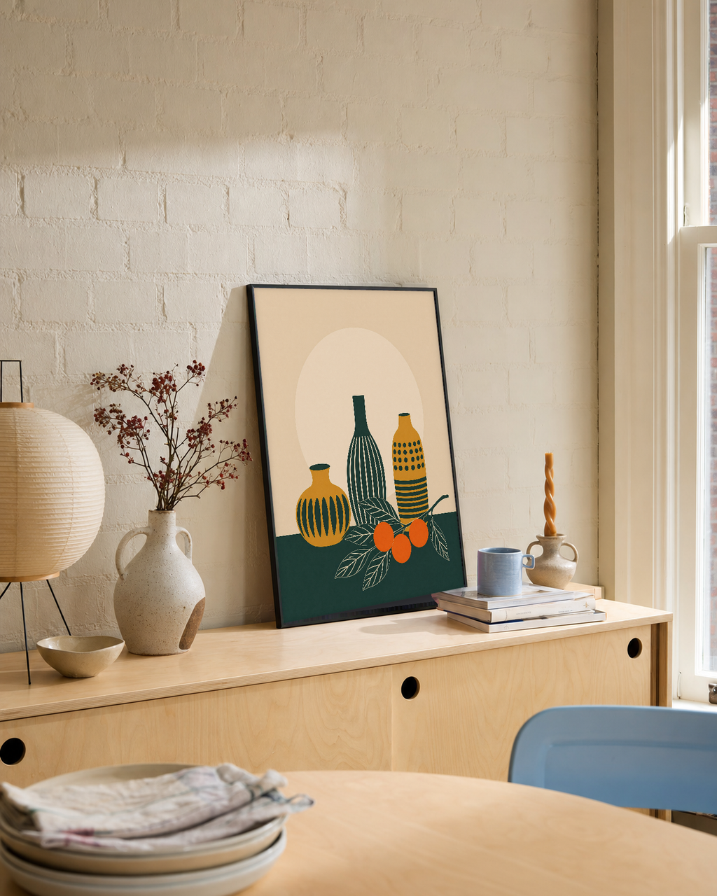 Twin Orange Sprigs Vertical unframed print is shown framed for styling in a dining console; frame not included