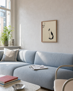 Ink Sitting Cat unframed print is shown framed for styling in a sofa wall; frame not included