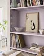 Ink Sitting Cat unframed print is shown framed for styling in a library shelf; frame not included