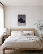 Charcoal Ridges unframed print is shown framed for styling in a bedroom; frame not included