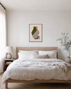 Olive Facet on Taupe Vessel olive green geometric wall art: unframed print is shown framed for styling in a bedroom; frame not included