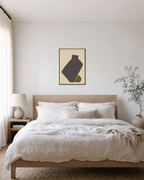 Olive Tilt olive green abstract vase wall art print: unframed print is shown framed for styling in a bedroom; frame not included