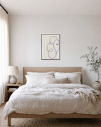The Glance blue line art face print: unframed print is shown framed for styling in a bedroom; frame not included