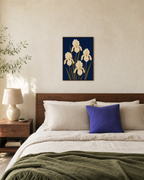 Cream Irises On Navy Field unframed print is shown framed for styling in a bedroom; frame not included