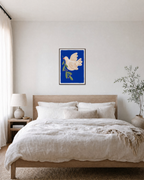 Left-Facing Bird on Blue Field blue dove wall art print: unframed print is shown framed for styling in a bedroom; frame not included