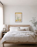 Morning Bottles citrus bottle still life wall art: unframed print is shown framed for styling in a bedroom; frame not included
