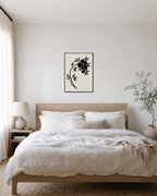 Black Leaves and Fruit black botanical silhouette wall art print: unframed print is shown framed for styling in a bedroom; frame not included
